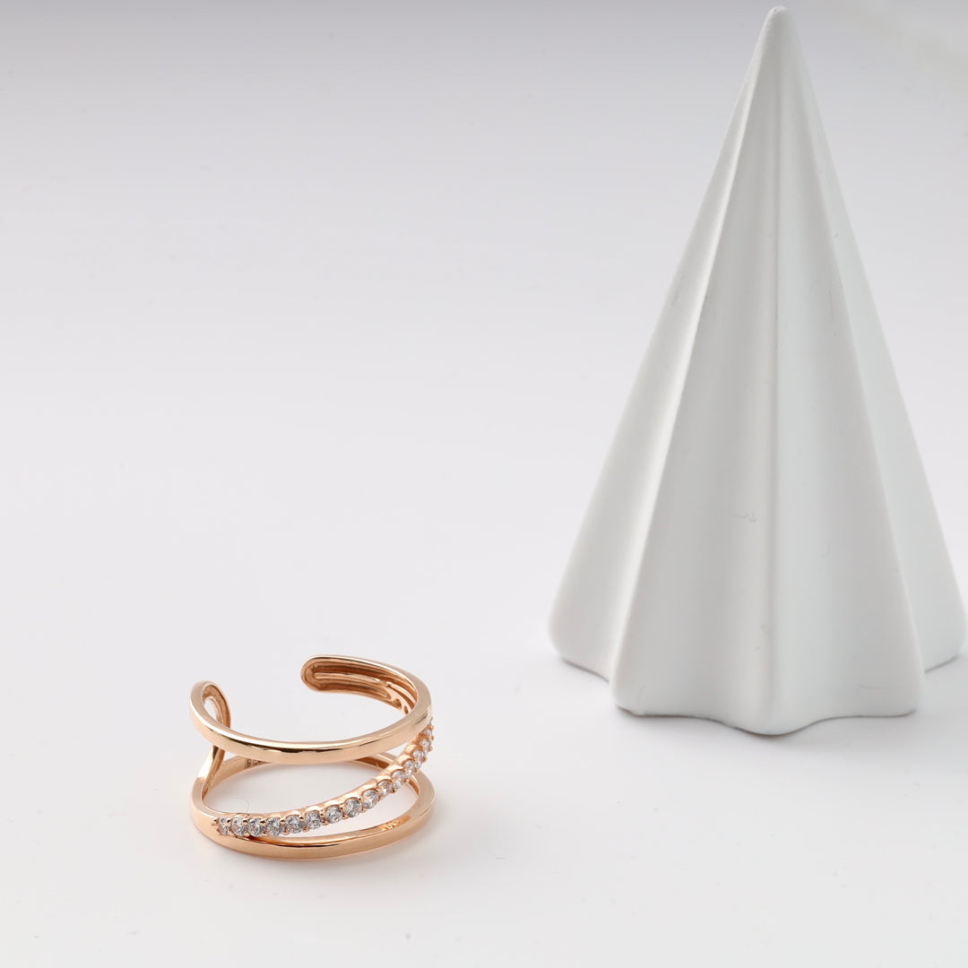 Gold tone open ring with clear rhinestones next to a white cone-shaped display.