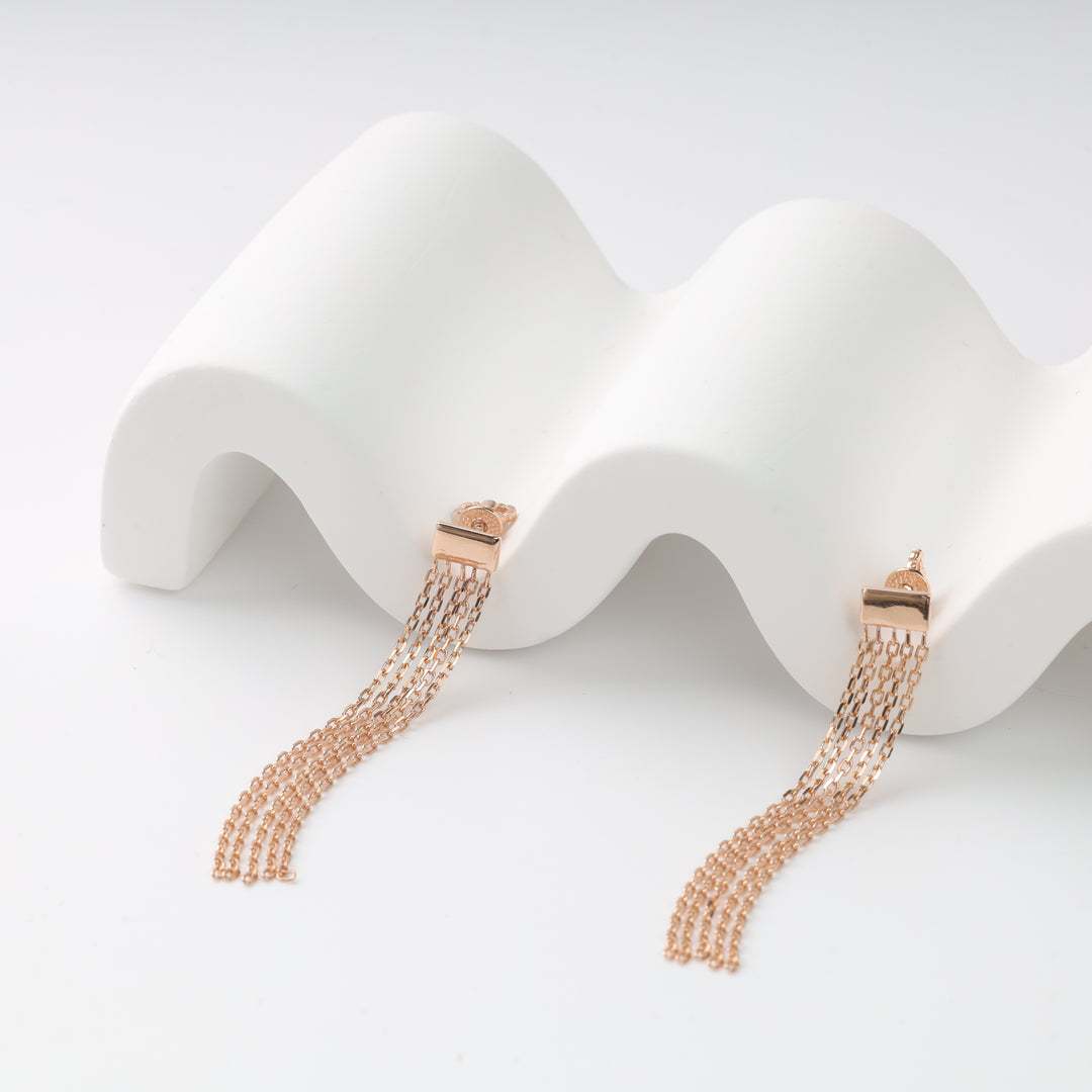 Pair of rose gold chain tassel earrings with bar studs on a white wave stand, rose gold tassel earrings, chain dangle earrings.