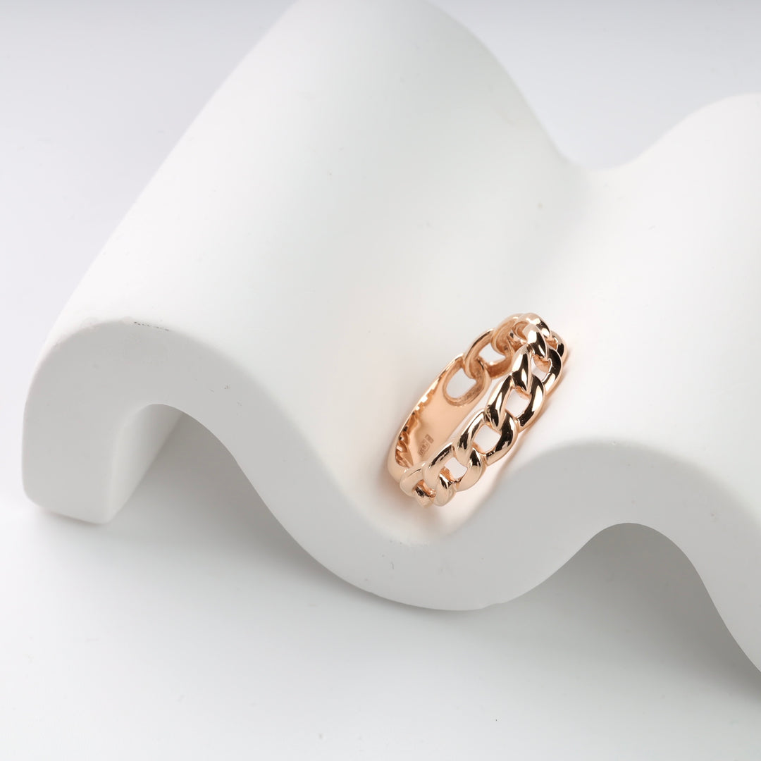Rose gold chain link ring on a white display.