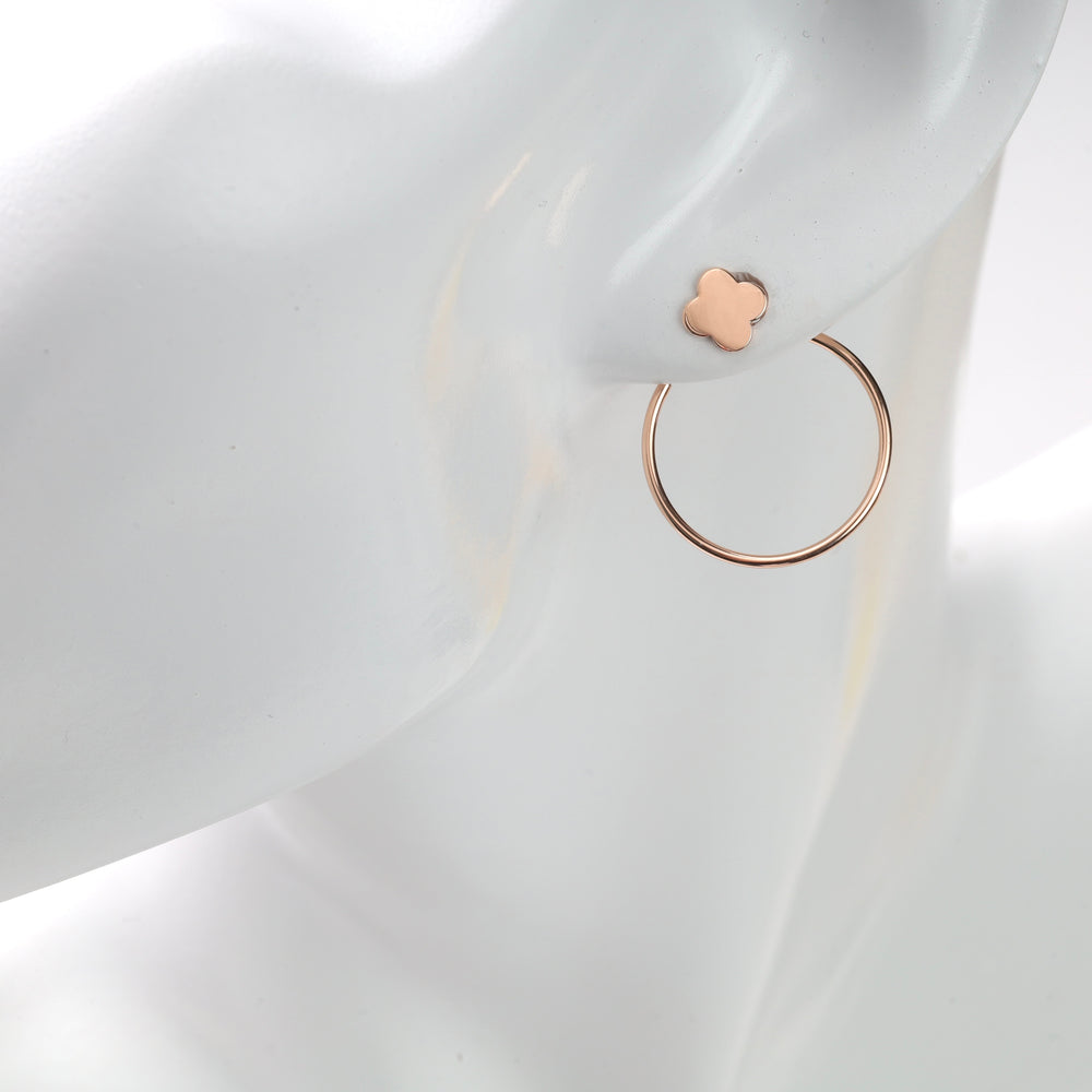 White mannequin ear wearing a rose gold clover stud and thin rose gold hoop earring.