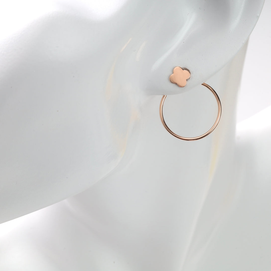 White mannequin ear wearing a rose gold clover stud and thin rose gold hoop earring.