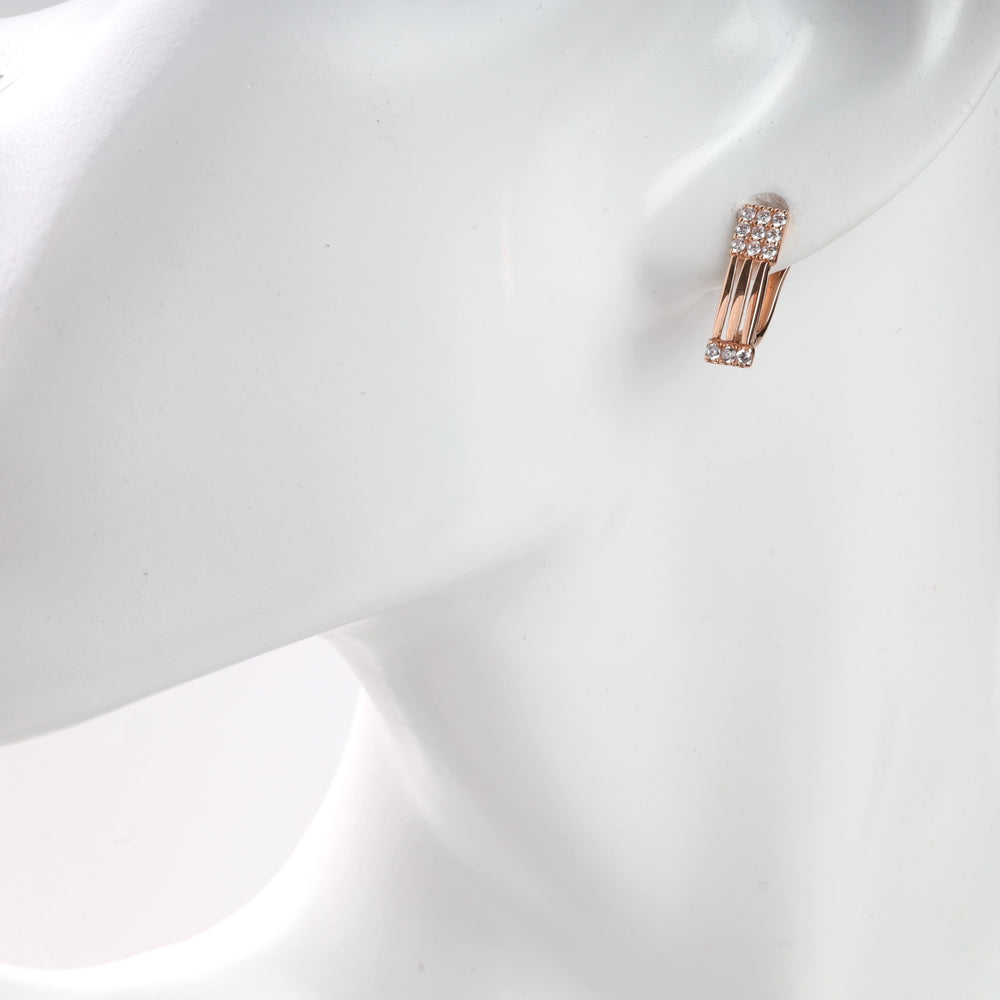Gold and diamond hoop earrings displayed on a mannequin.