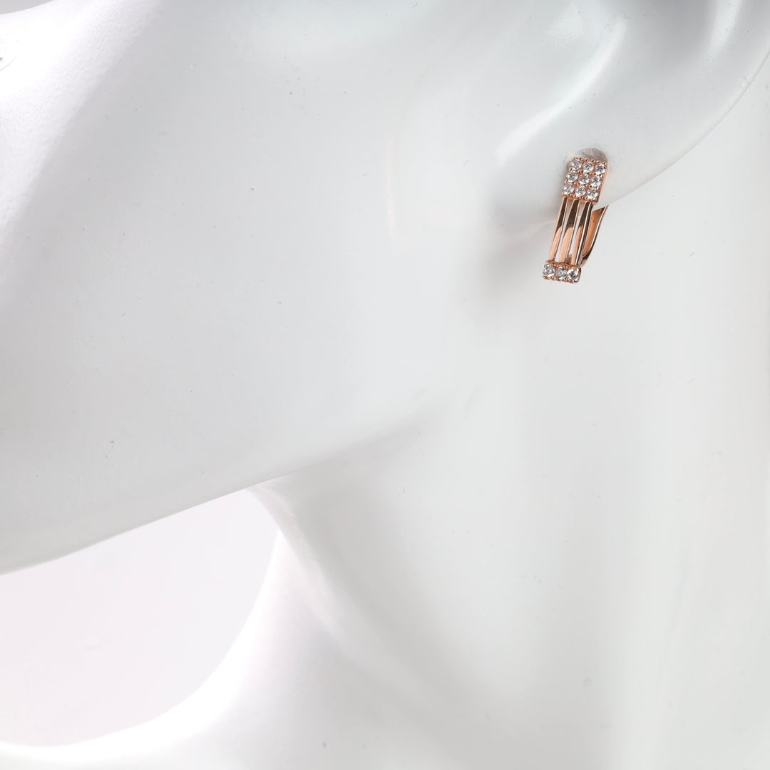 Gold and diamond hoop earrings displayed on a mannequin.