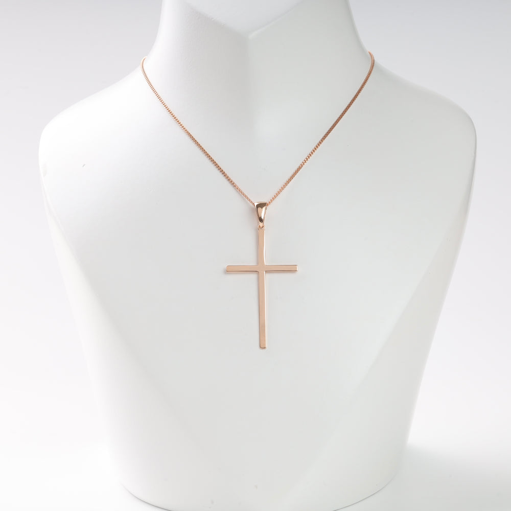 Rose gold cross pendant necklace with a simple design displayed on a white bust, minimalist jewelry, religious necklace.