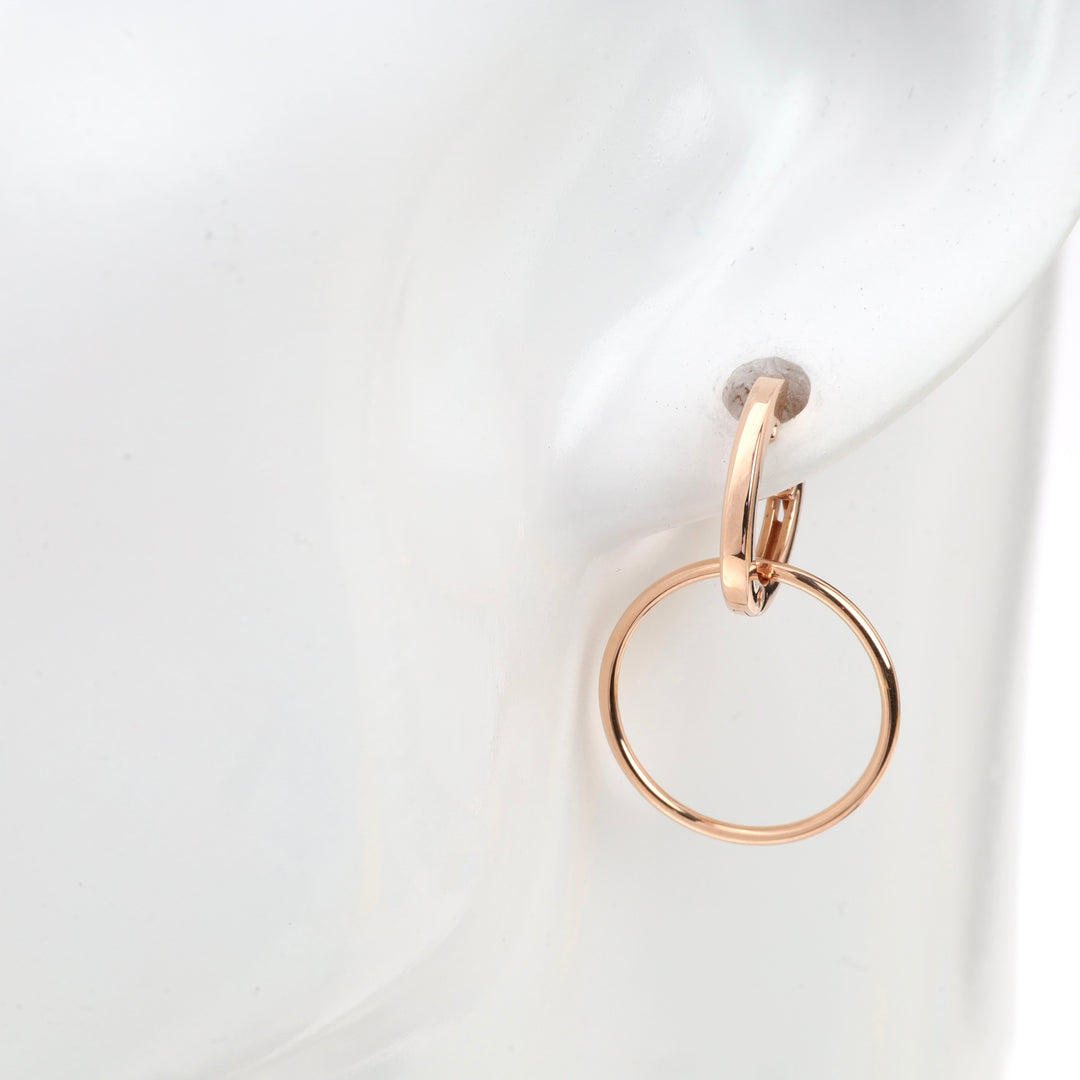 Rose gold hoop earring displayed on a white mannequin.