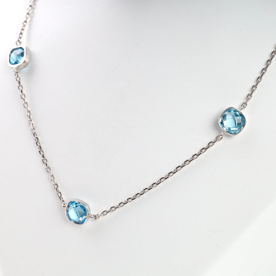 Silver chain necklace with three blue crystal charms.