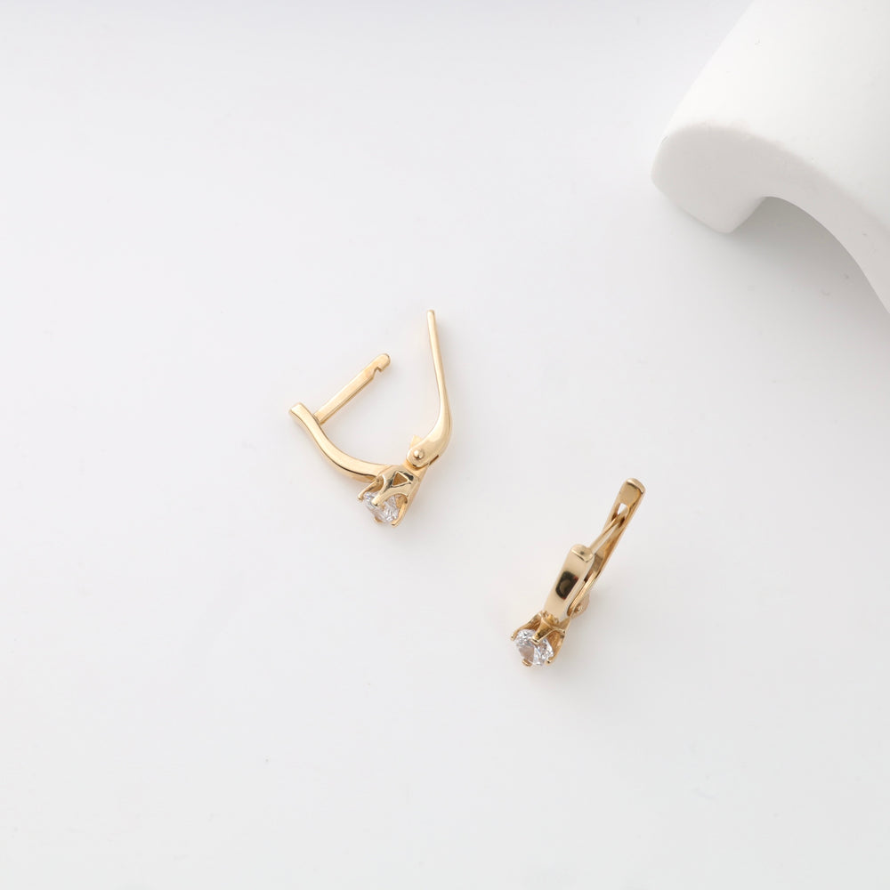 Gold hoop earrings with small gemstones on a white background.