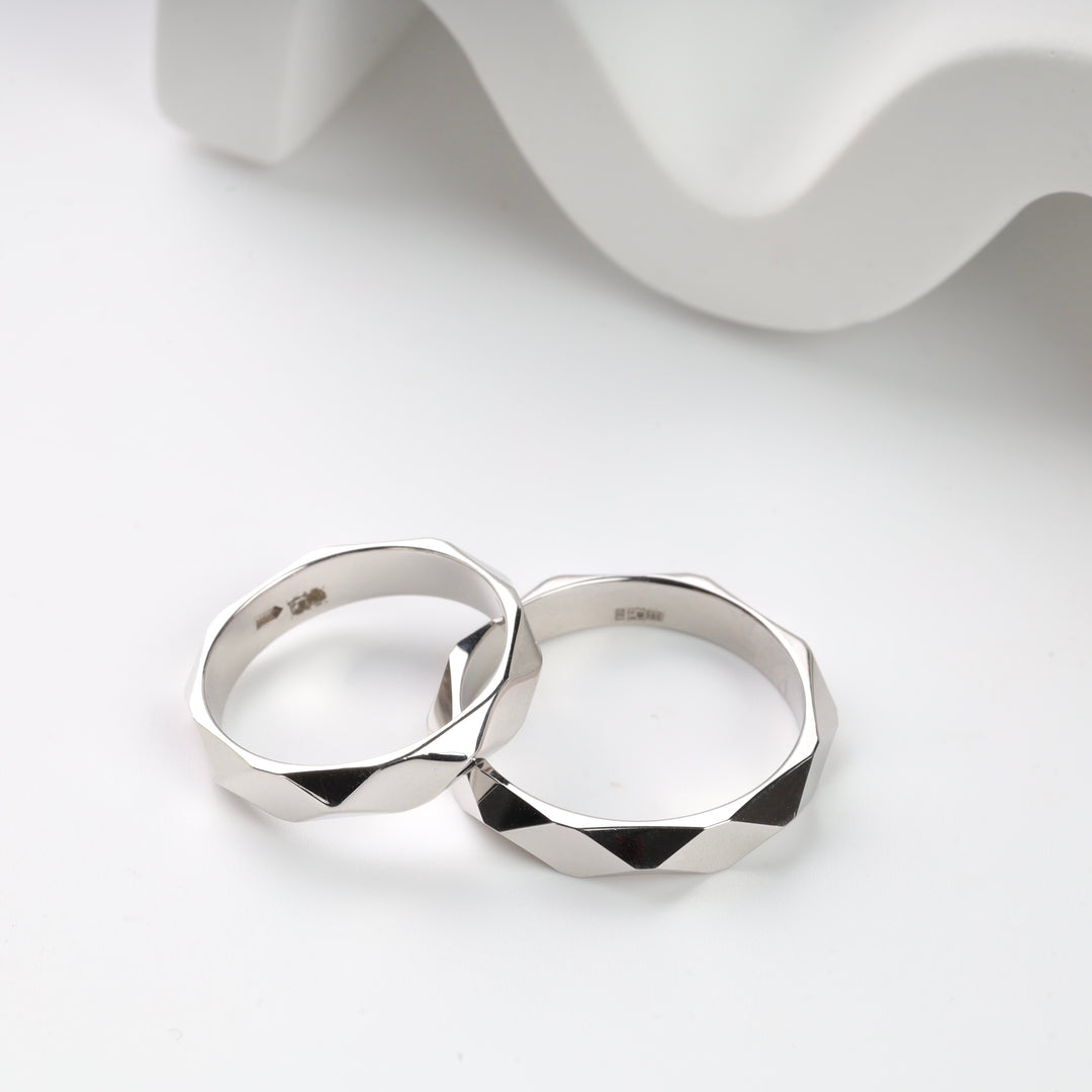 Two silver geometric patterned rings on a white background.