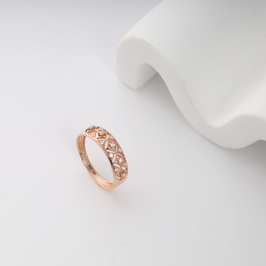Rose gold diamond lattice ring on a white surface.