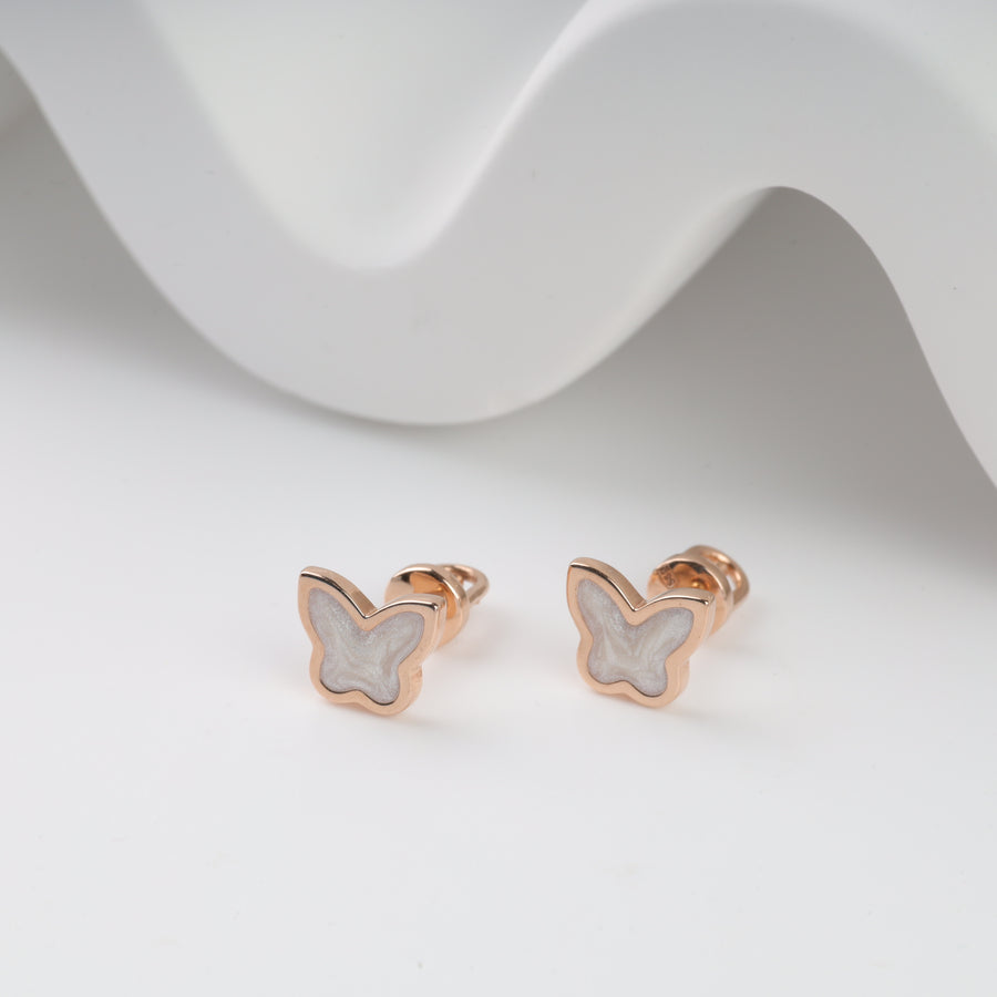 Rose gold butterfly stud earrings with white enamel accents.