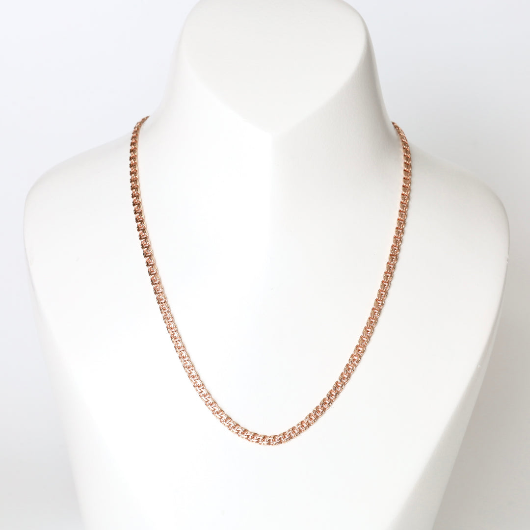 Rose gold chain necklace displayed on a white bust, classic curb link jewelry.