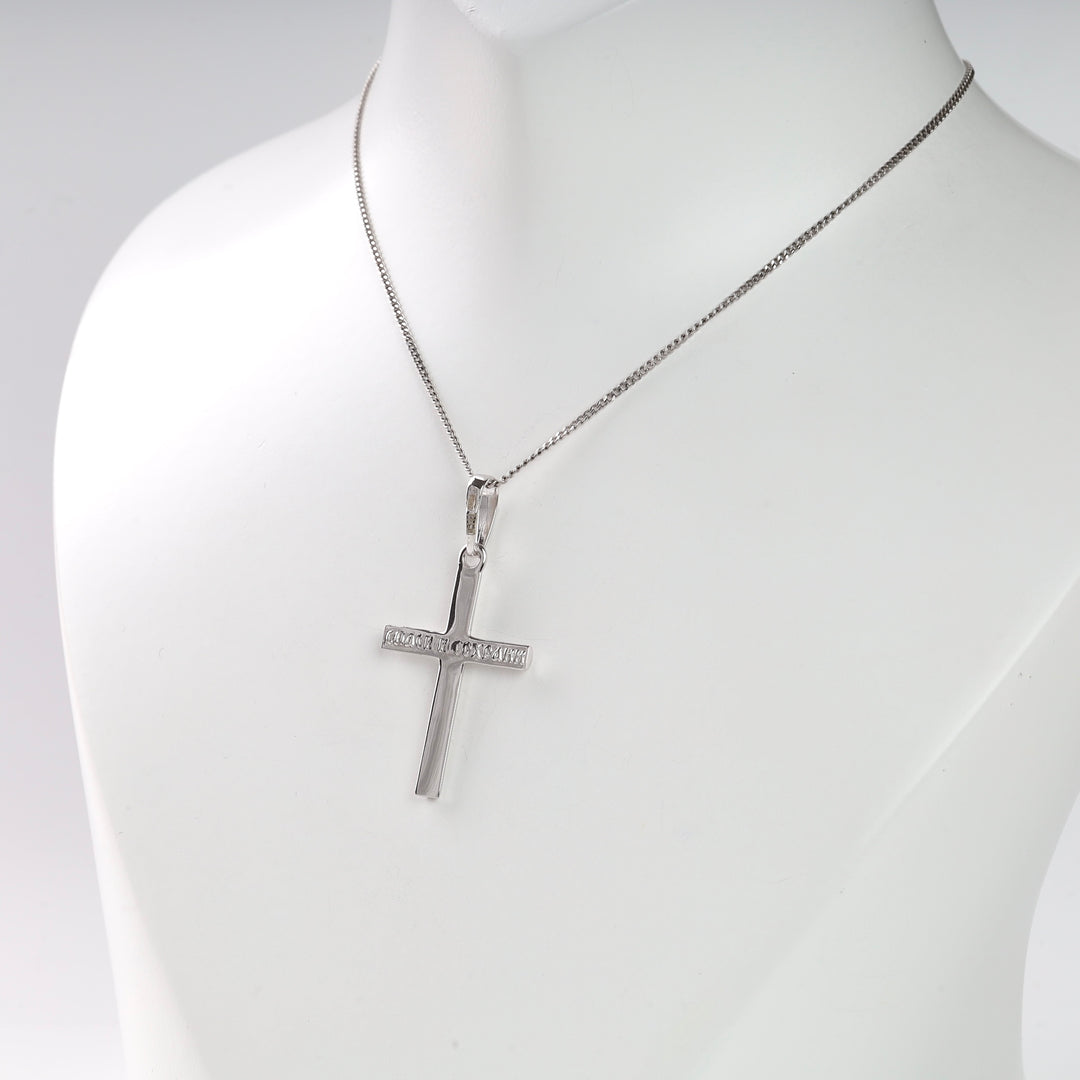 Silver cross pendant necklace with simple chain displayed on a bust.