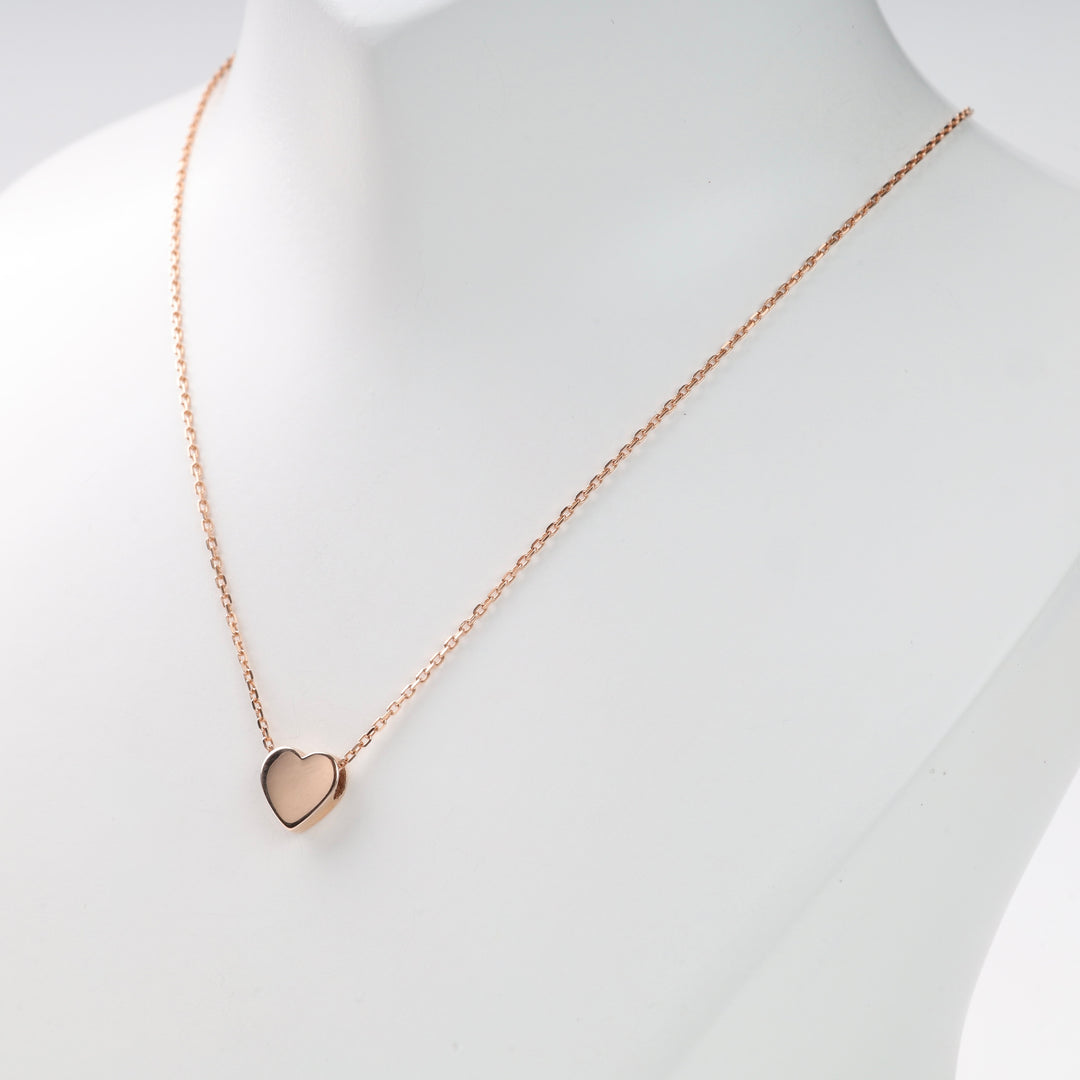 Rose gold heart pendant on chain displayed on white bust, rose gold heart necklace, rose gold necklace, heart pendant.