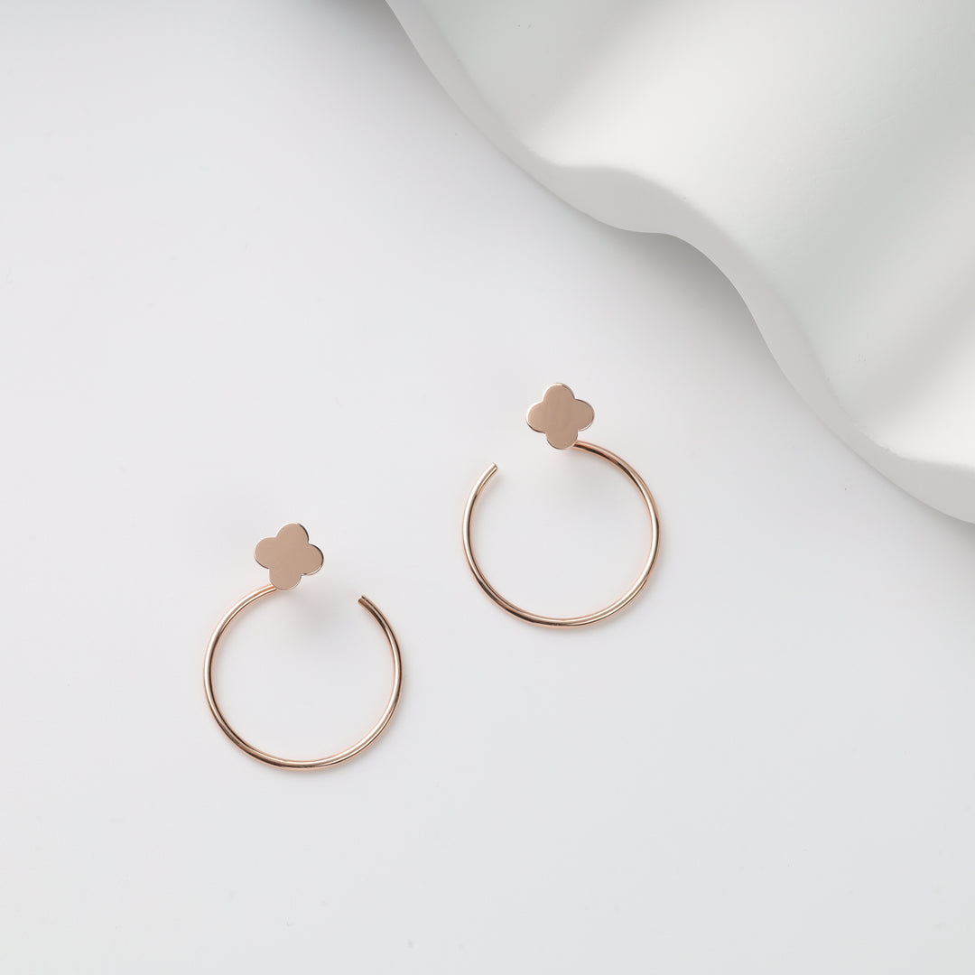 Rose gold open hoop pair with clover stud tops on white background, rose gold hoop earrings, clover stud hoops.