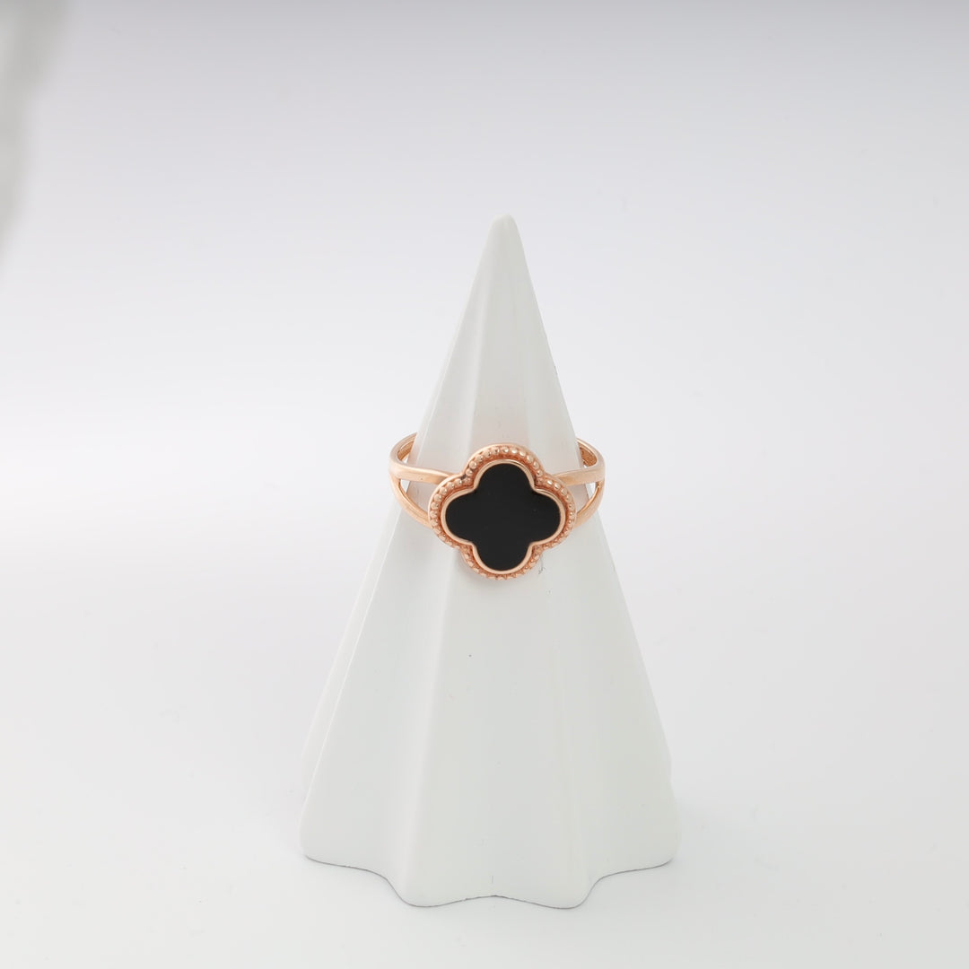Rose gold clover ring with black enamel on a white display cone.
