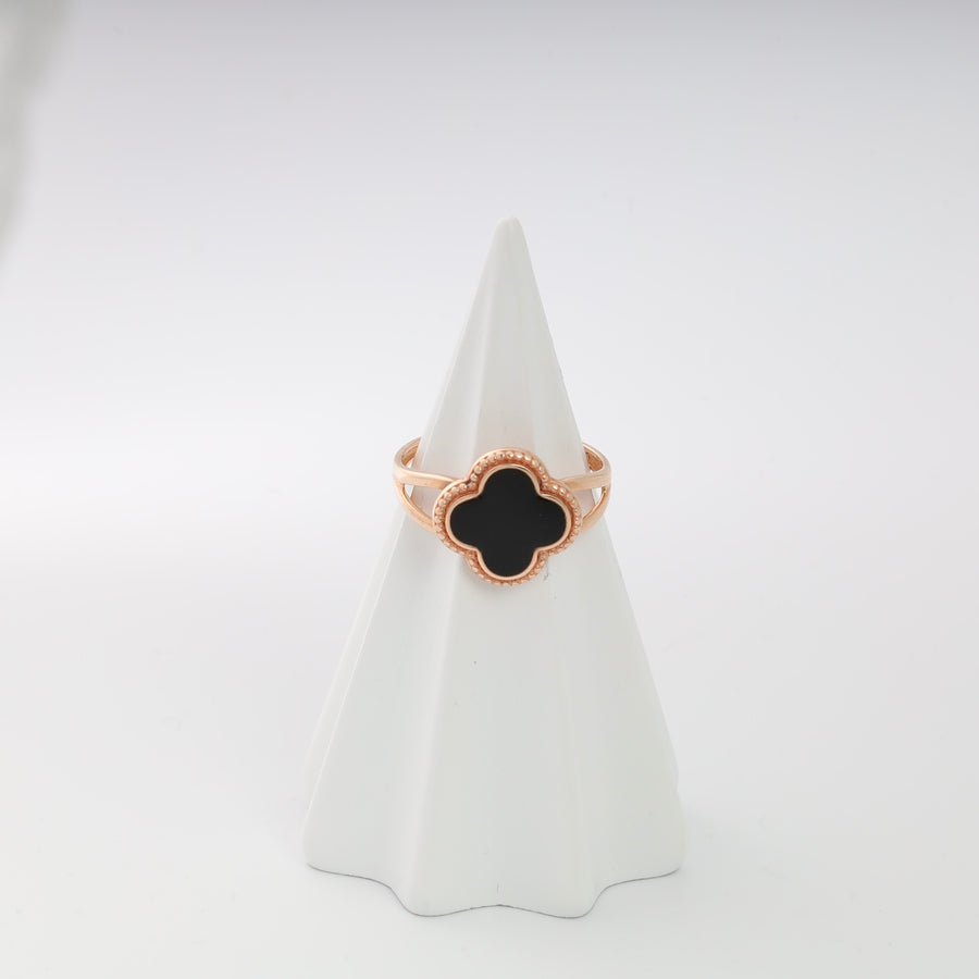 Rose gold clover ring with black enamel on a white display cone.