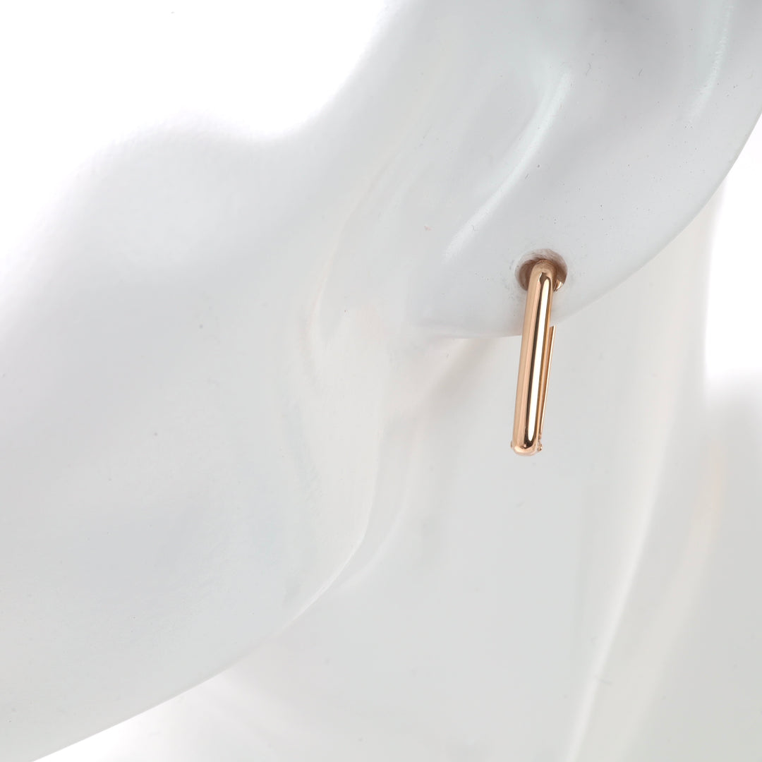 Gold hoop earring displayed on a mannequin.