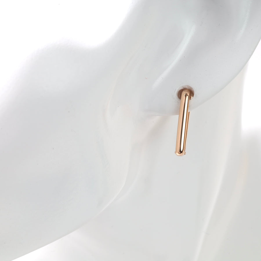 Gold hoop earring displayed on a mannequin.