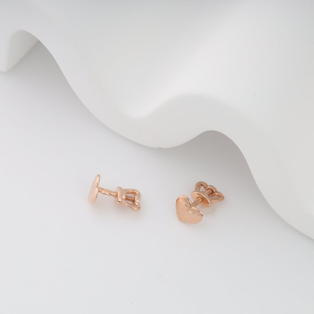Rose gold heart-shaped baby earrings with screw-back displayed on a white background.