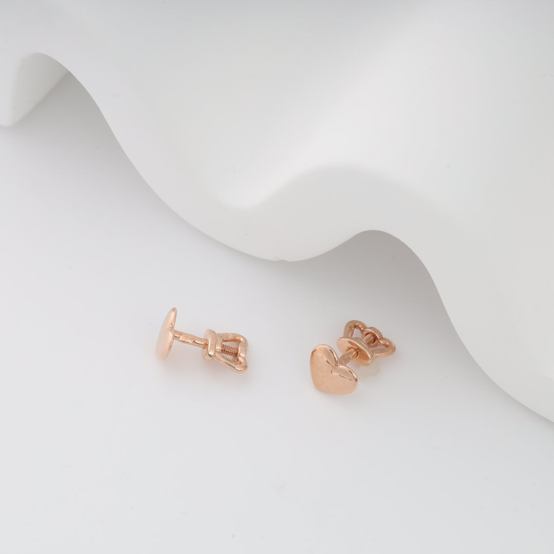Rose gold heart-shaped baby earrings with screw-back displayed on a white background.