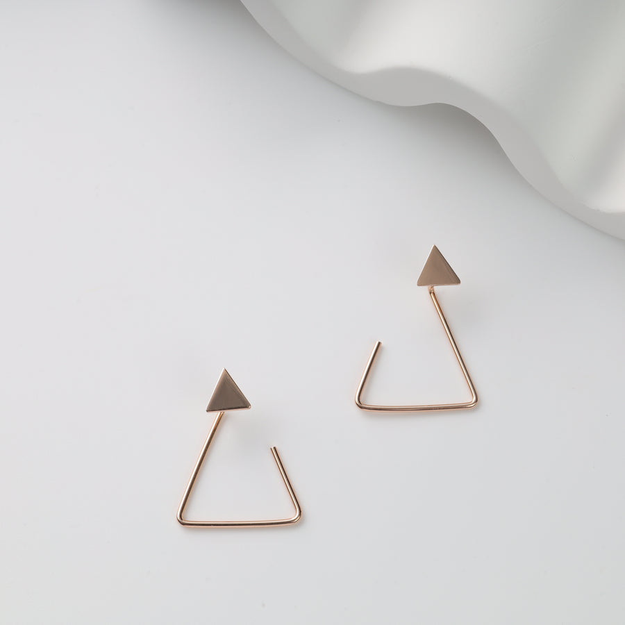 Pair of rose gold triangle hoop earrings with solid triangle studs on white background, geometric stud earrings.