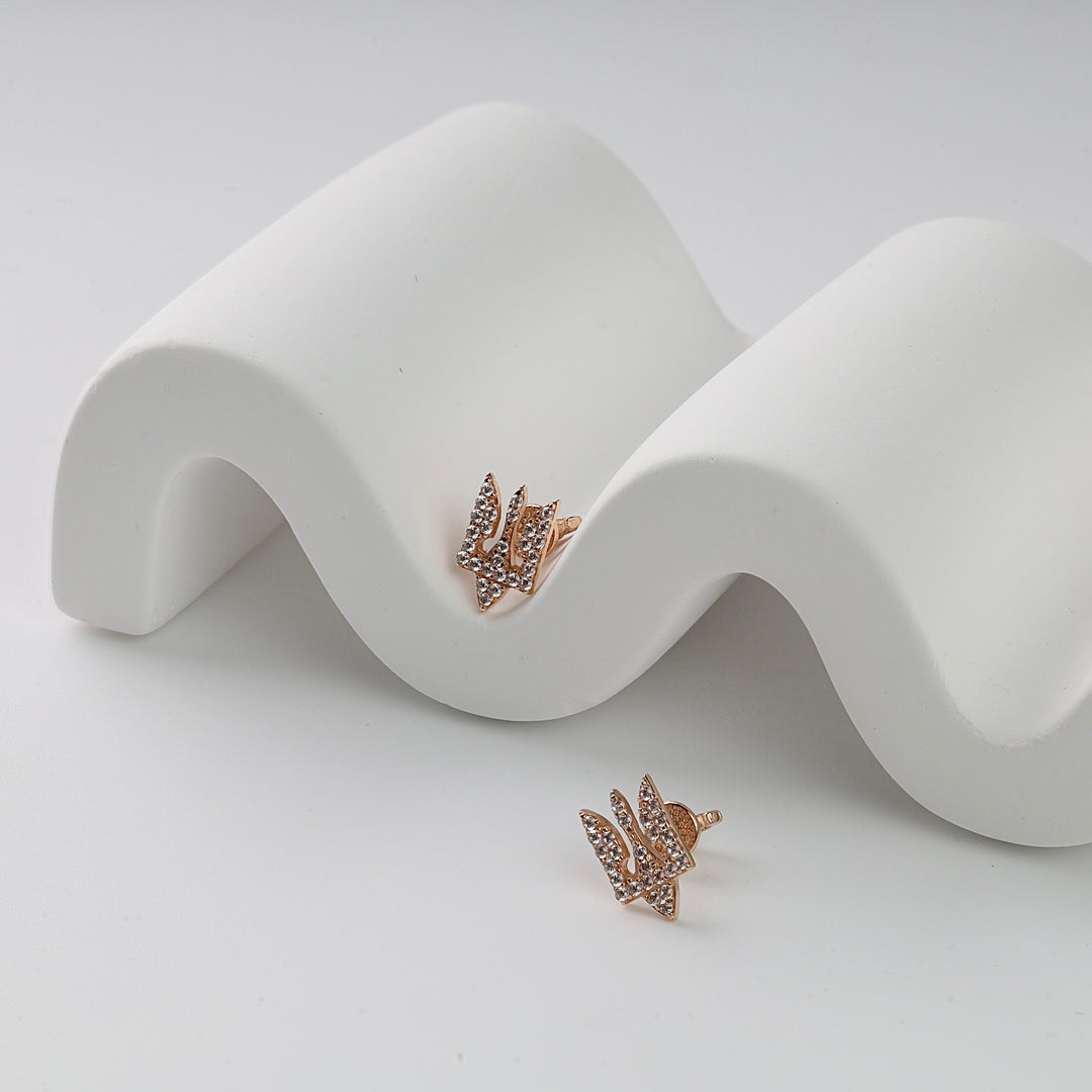 Rose gold stud earrings with geometric zigzag shape and clear crystals, shown on a white wavy display.