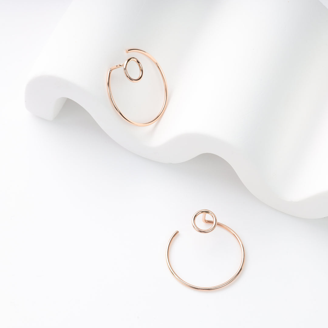 Pair of rose gold wire hoop earrings with small circle motif on white wavy display, rose gold hoop earrings, minimalist circle hoops.