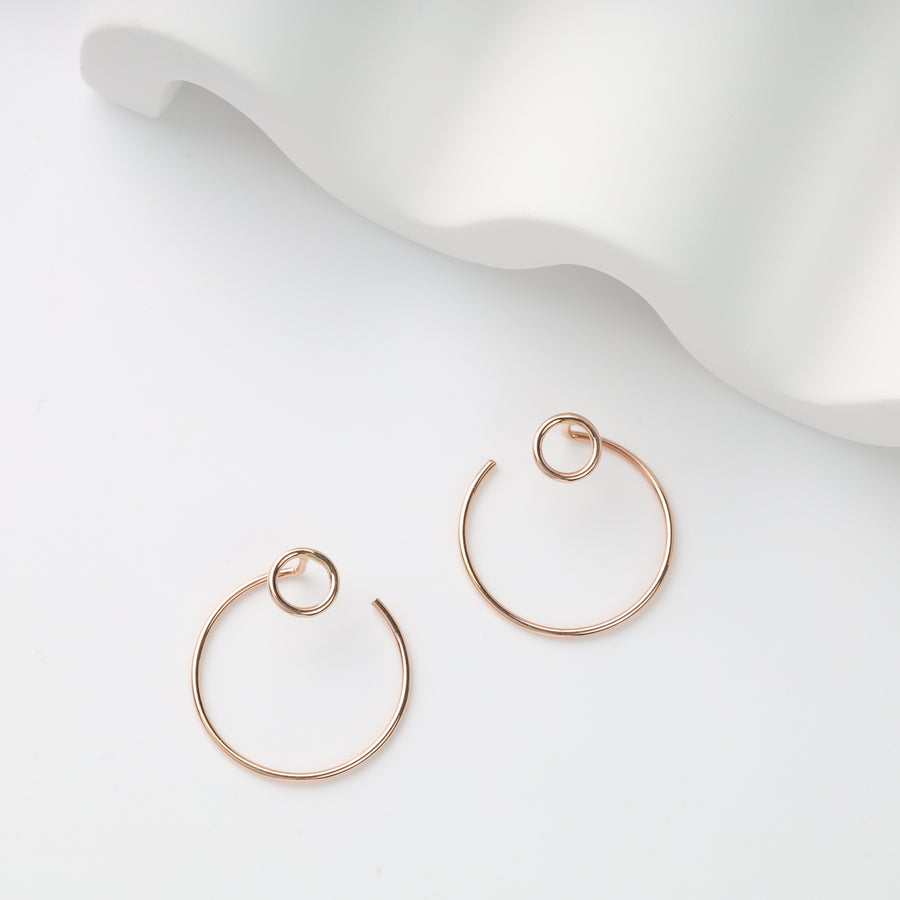 Pair of rose gold wire hoop earrings with loop detail on white background, rose gold hoop earrings, minimalist wire earrings.