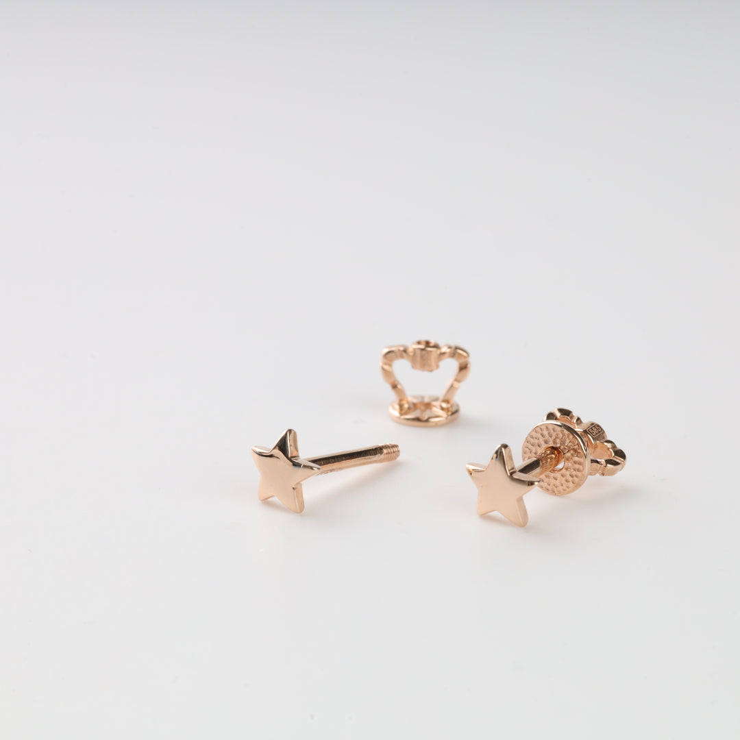 Rose gold star-shaped stud earrings on a white background.