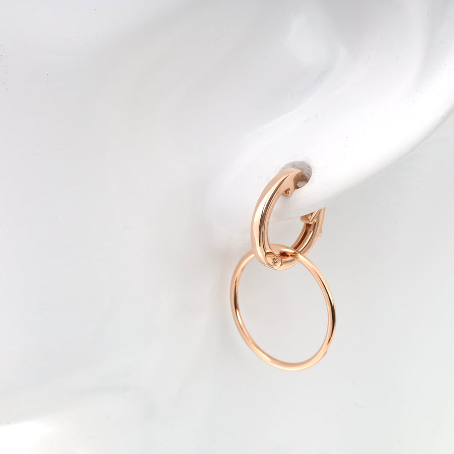 Rose gold hoop earrings displayed on a white mannequin.