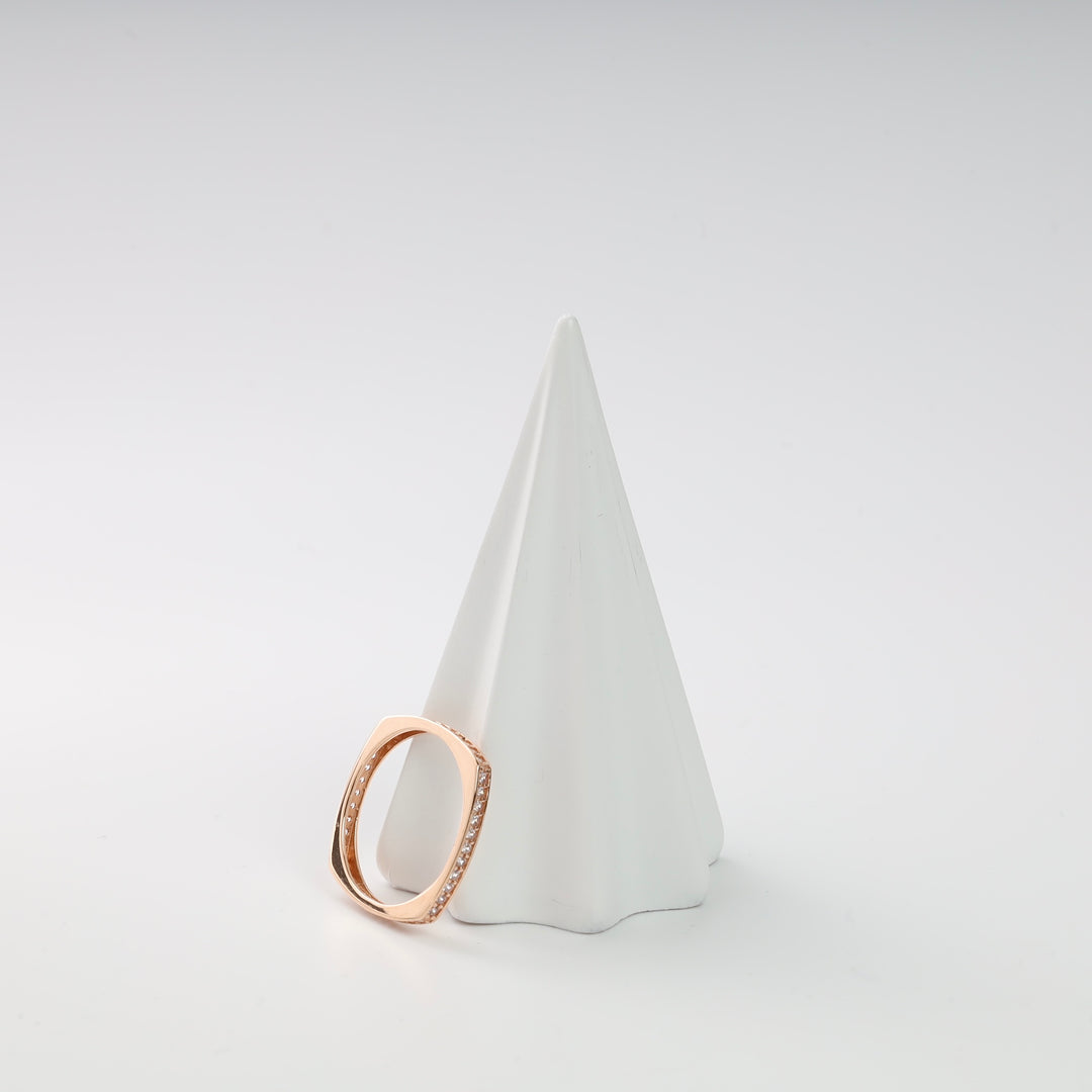 Rose gold square ring with small clear stones shown on a white cone display.