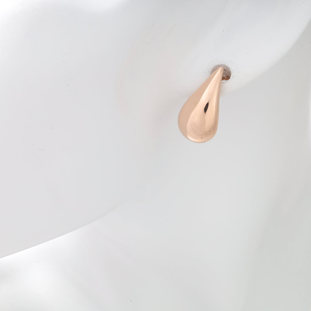 One polished rose gold teardrop stud earring on a white mannequin ear, rose gold teardrop stud, teardrop stud earring.