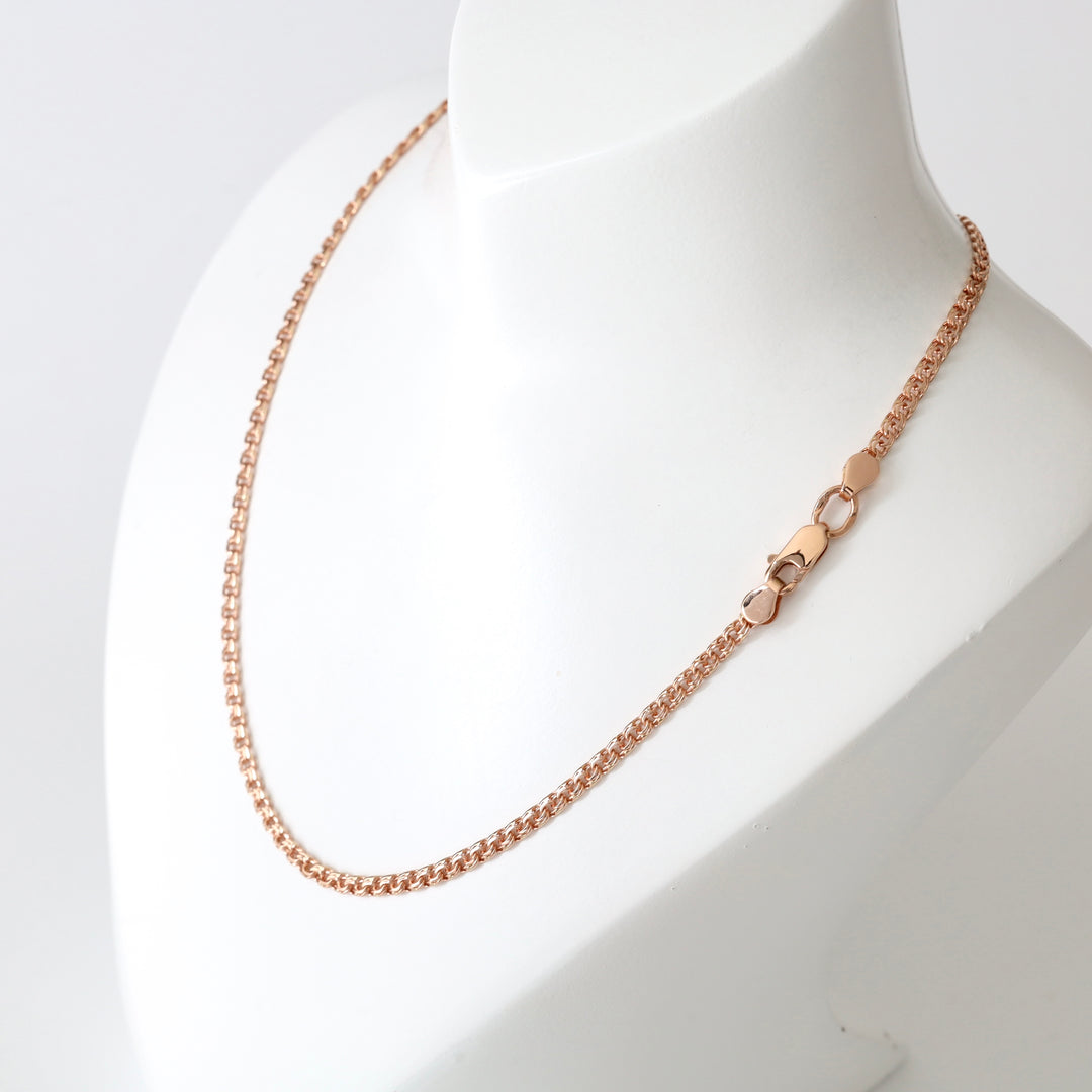 Rose gold chain necklace with a lobster clasp displayed on a white mannequin bust.