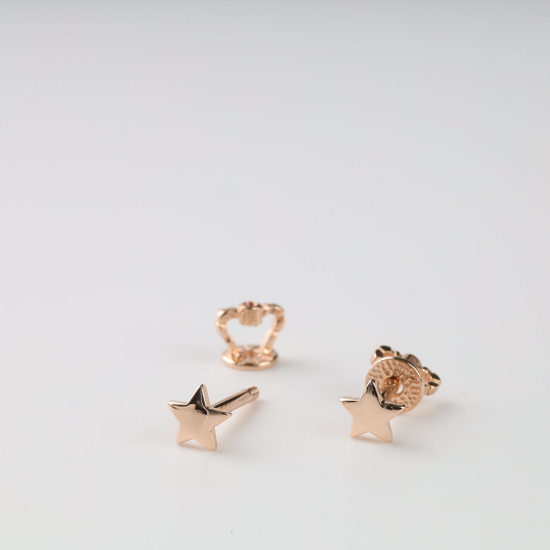 Gold star stud earrings on a white background.