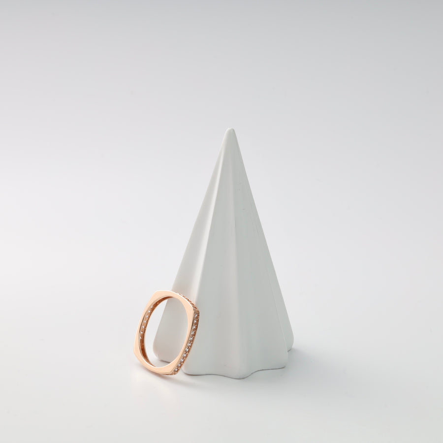 Square rose gold ring with small diamonds on a white cone display.