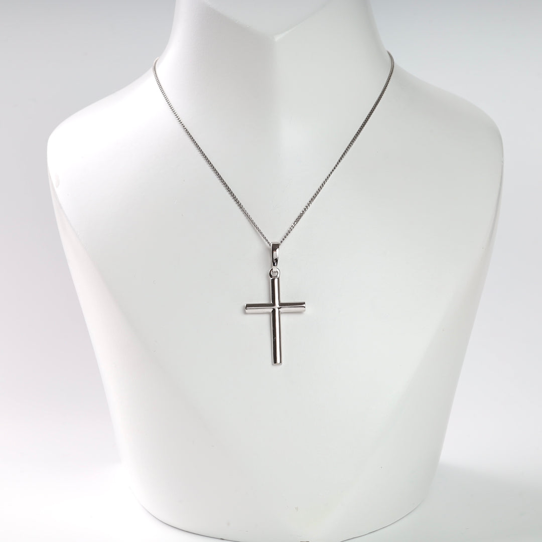 Silver cross pendant necklace on a display bust.