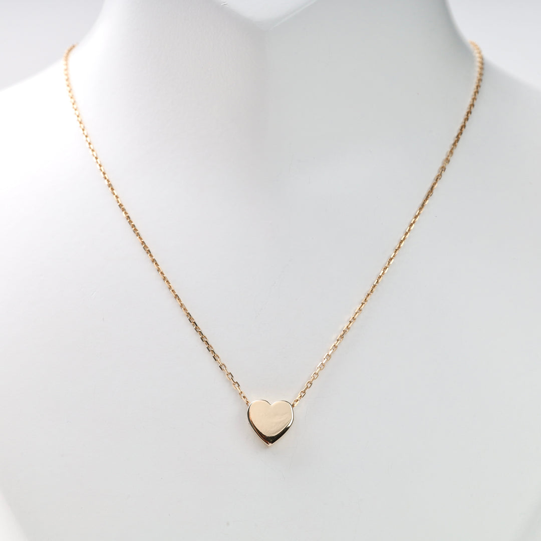 Gold heart pendant on a single gold chain shown on a white display bust, gold heart necklace, heart pendant, gold chain necklace.