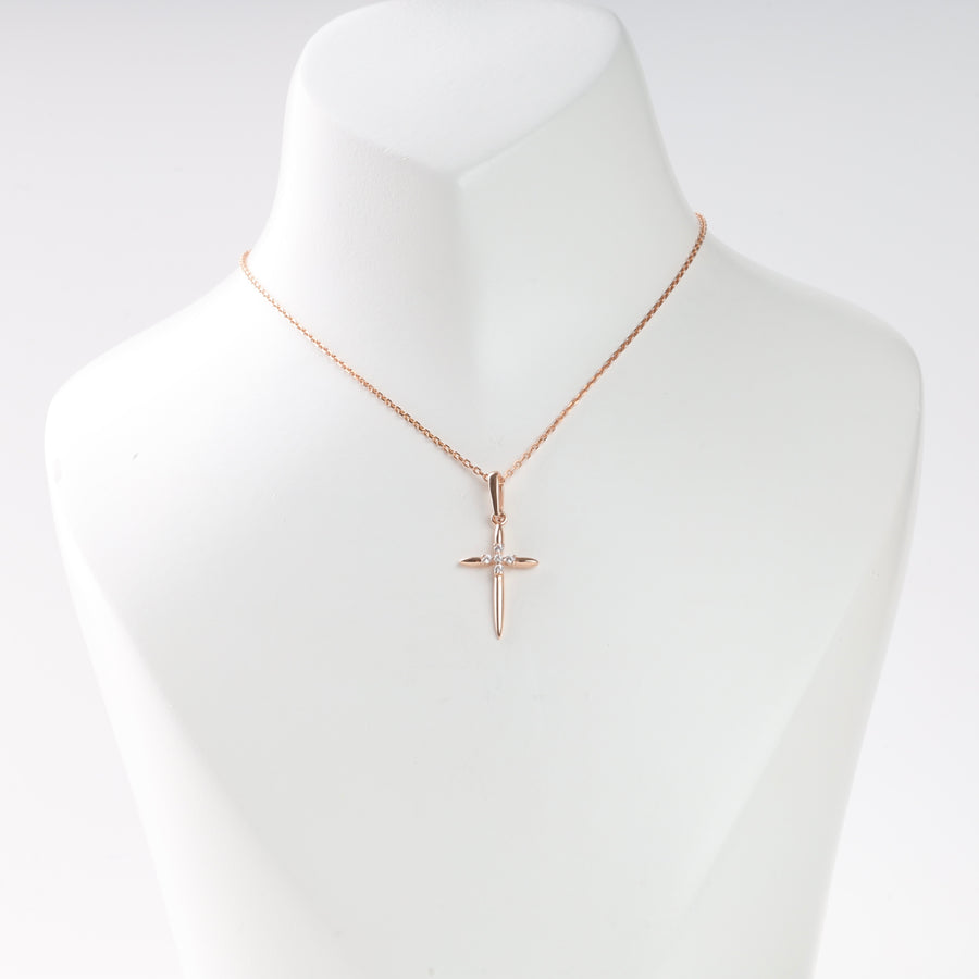 Rose gold cross pendant necklace with a single clear stone, displayed on a white bust. Cross necklace, rose gold jewelry.
