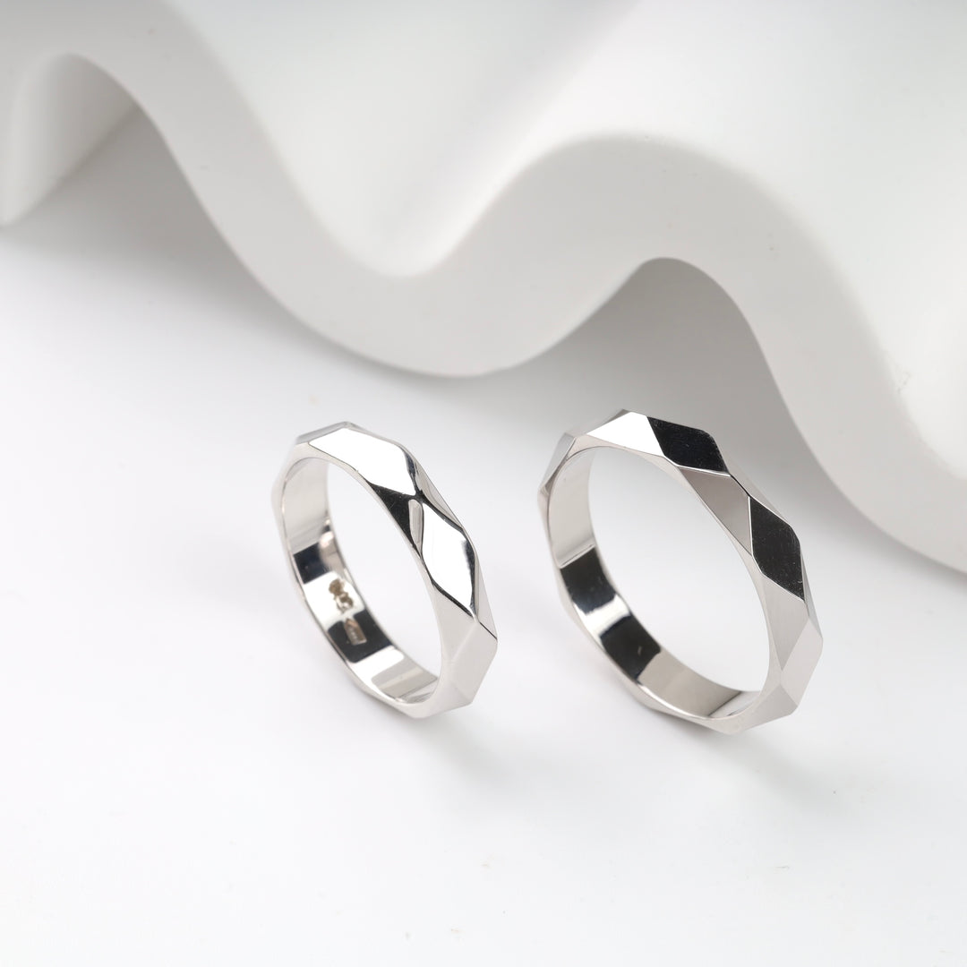 Geometric silver rings with faceted design on a white background.