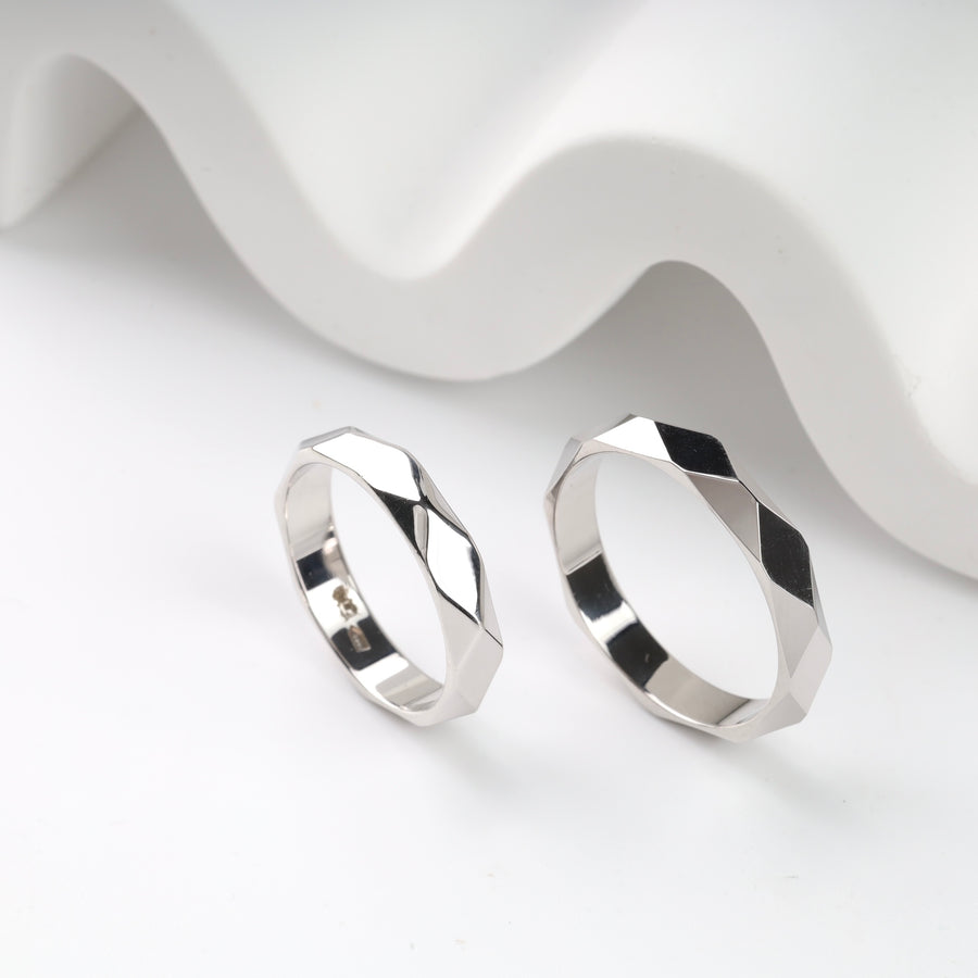 Geometric silver rings with faceted design on a white background.