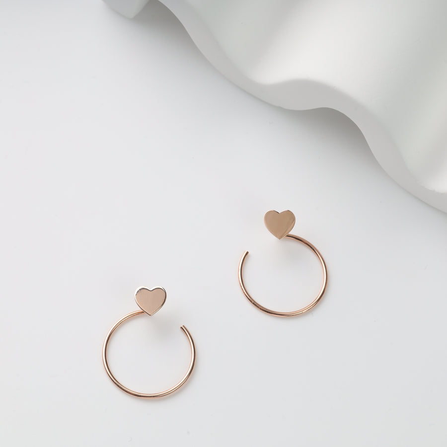 Pair of rose gold open hoop earrings with flat heart tops on white background, rose gold heart hoop earrings, heart stud hoops.