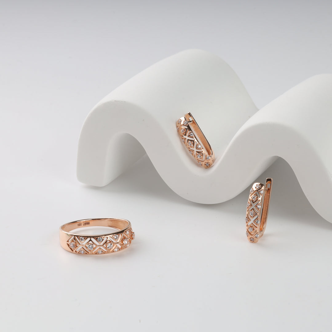 Rose gold jewelry set with a quilted pattern, includes two hoop earrings and a ring, displayed on white wavy stands.