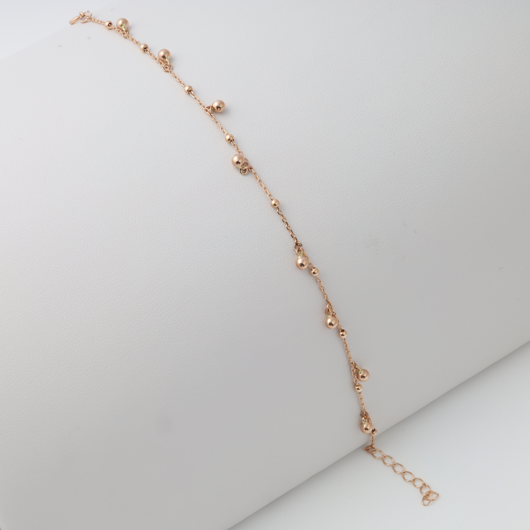 Delicate 14k gold beaded chain bracelet with adjustable clasp on display pillow, Ukrainian Jewelry for minimalist gold bracelet shoppers.