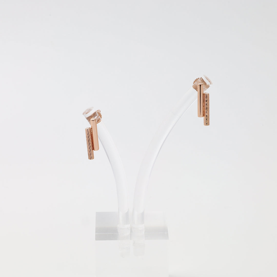 Rose gold 14k gold bar stud earrings with textured drop design on display stand, minimalist Ukrainian Jewelry for women.