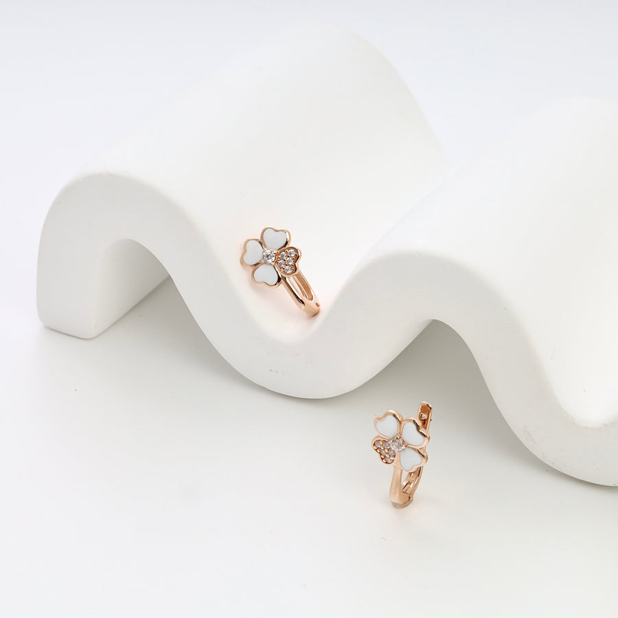 14k gold clover earrings with white enamel hearts and crystals on display, Ukrainian Jewelry, dainty floral hoop earrings.