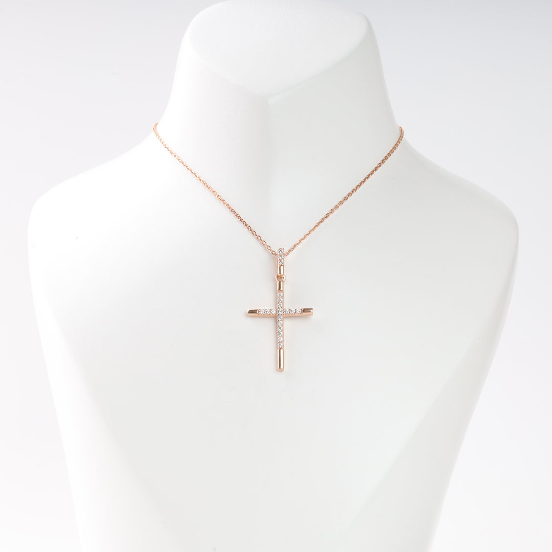 Rose gold cross pendant necklace with small clear stones on a display bust, Christian jewelry, minimalist gift.