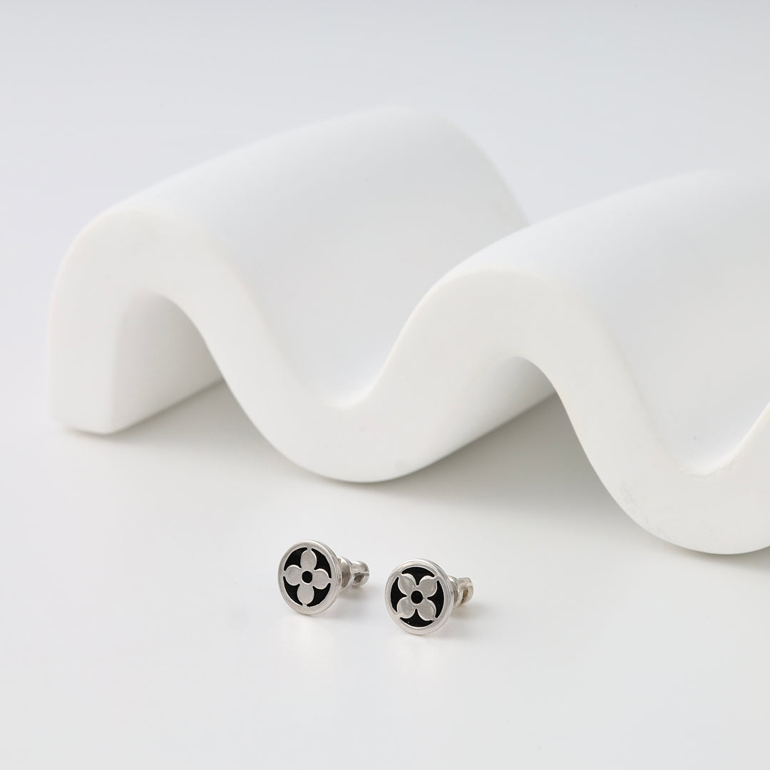 Sterling silver stud earrings with black enamel clover design on white display, Ukrainian Jewelry, minimalist silver studs.