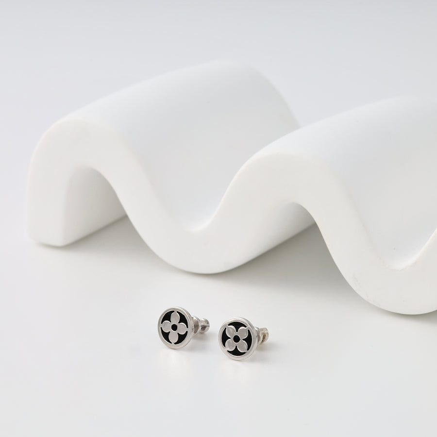 Sterling silver stud earrings with black enamel clover design on white display, Ukrainian Jewelry, minimalist silver studs.
