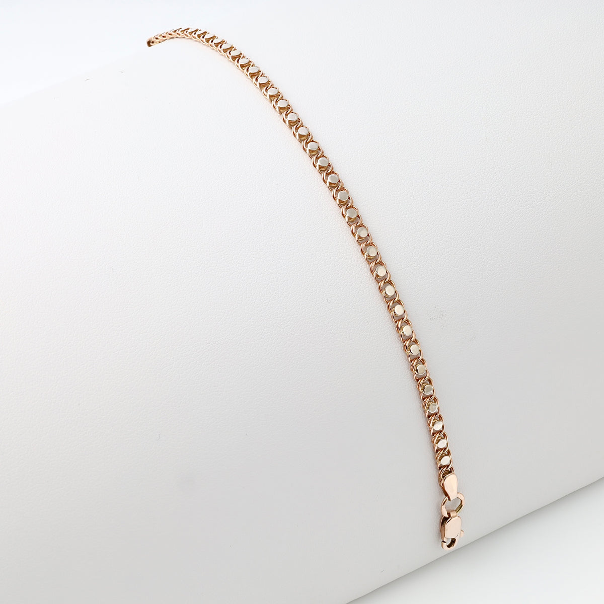 Rose gold chain link bracelet in 14k gold, clasped and displayed on a white cushion, classic Ukrainian Jewelry gift bracelet.