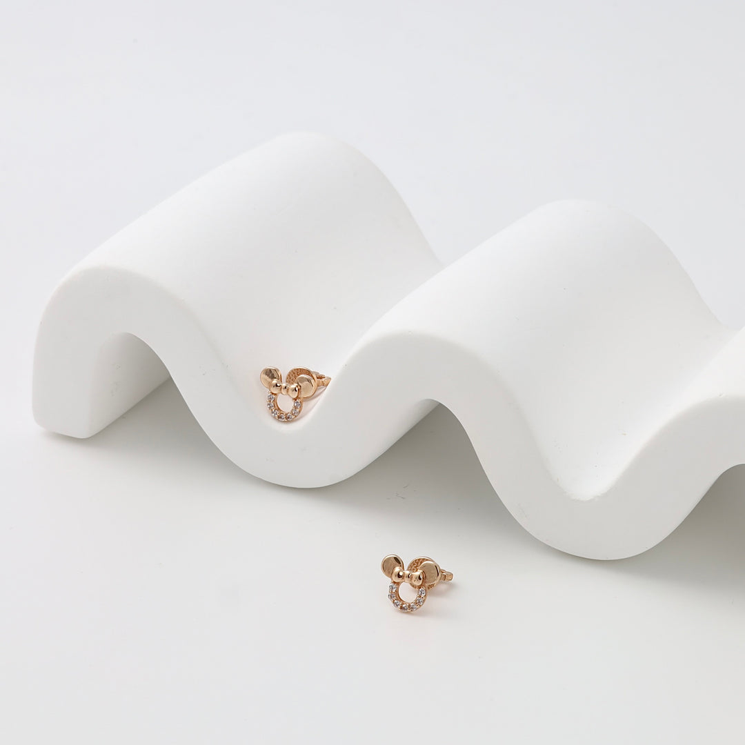 Pair of 14k gold bow and circle stud earrings with cubic zirconia on white display, Ukrainian Jewelry, dainty gold earrings.